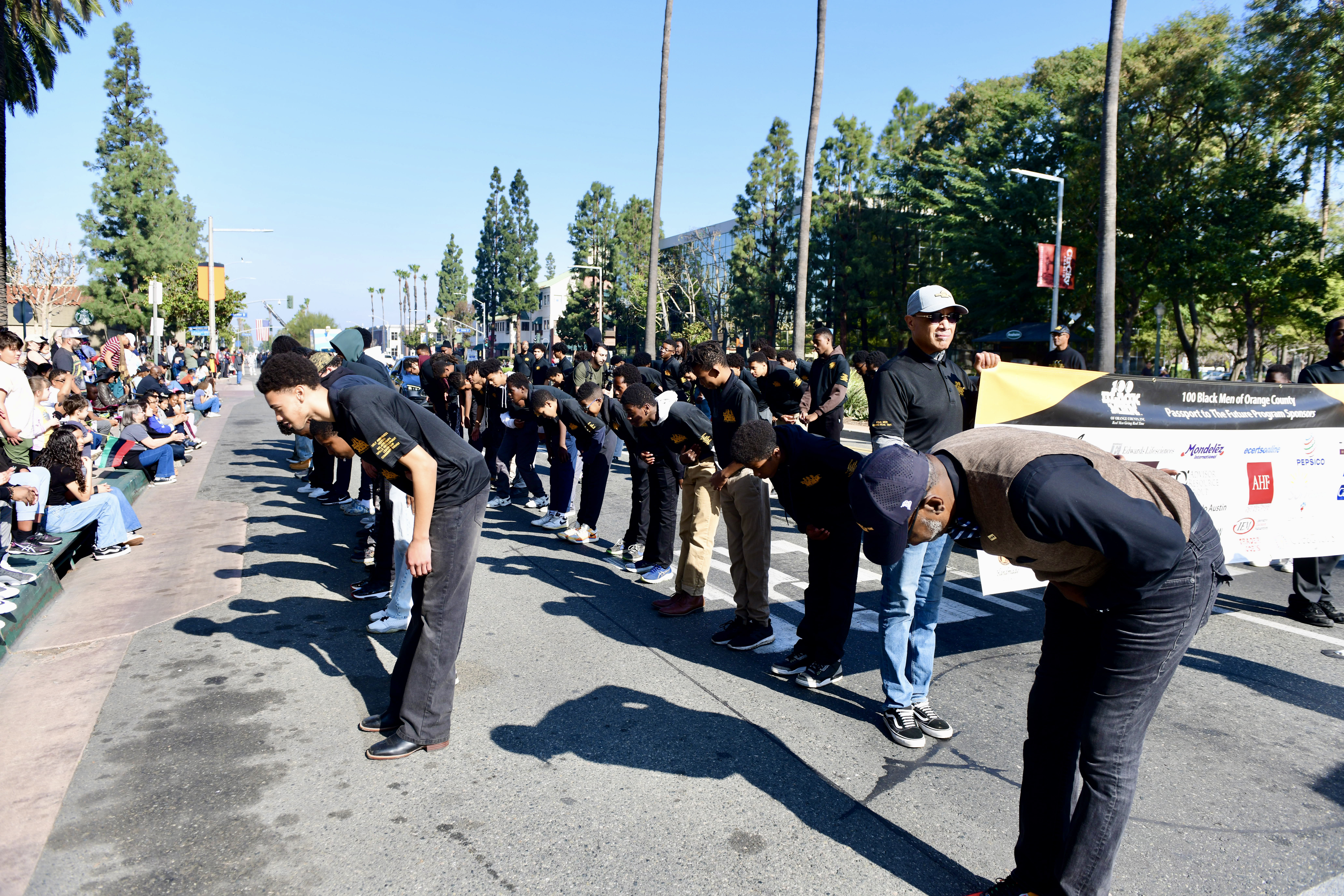 Crowd of people bowing or stretching outdoors