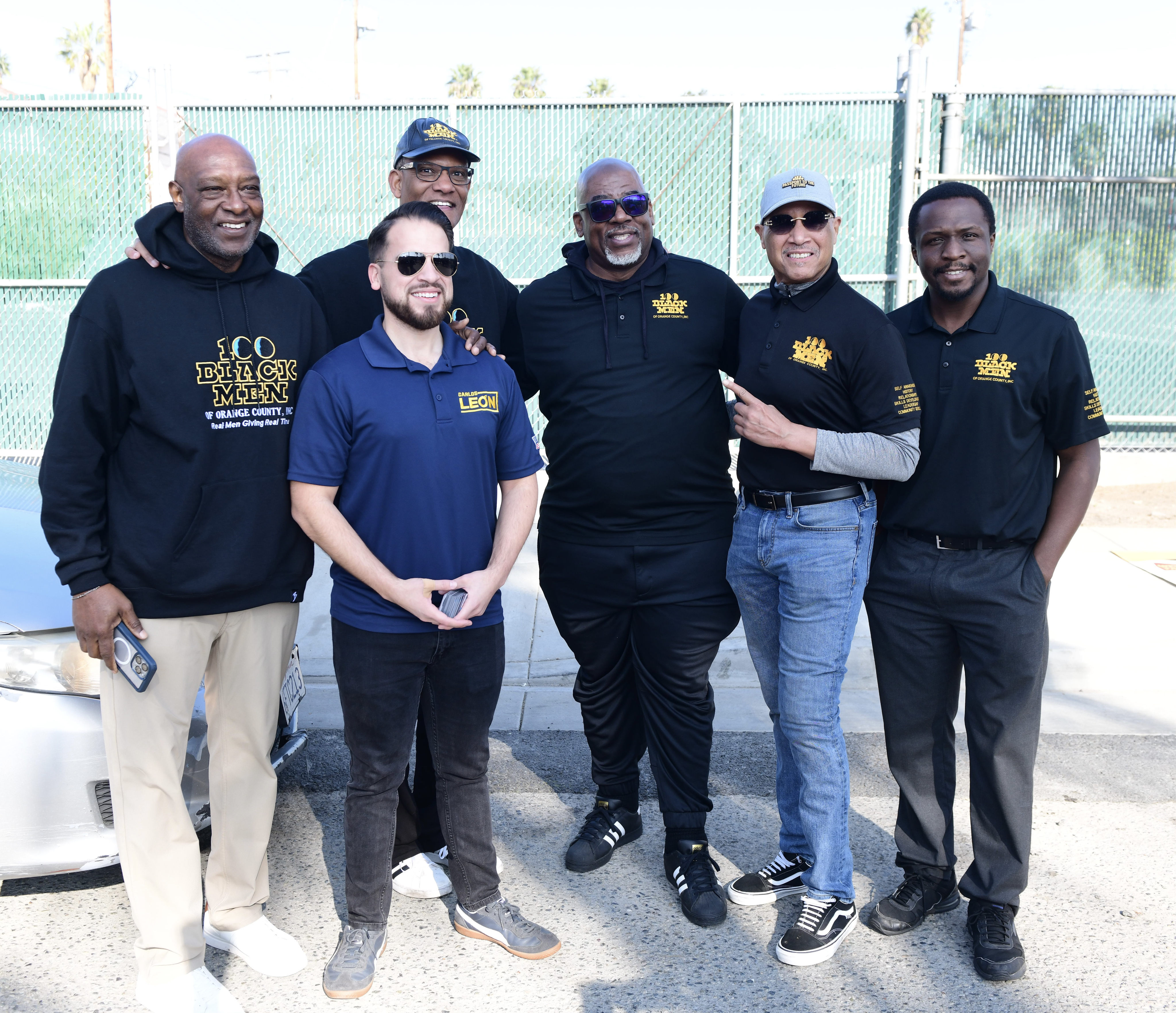 Five men standing together in black and blue shirts